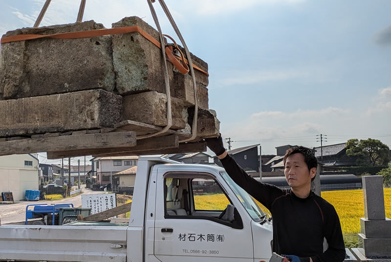 クレーンで墓じまいの墓石を持ち上げて作業をしている筒木社長の写真